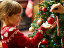 Menina enfeita &aacute;rvore de Natal